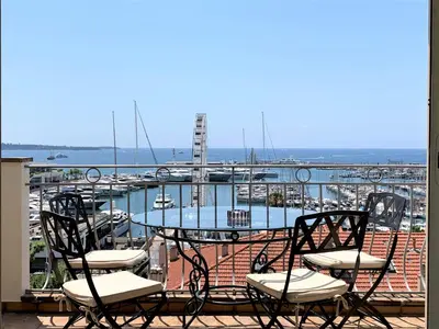 a table and chairs on a balcony with a marina at O Festival Palace, terrace with panoramic sea view in Cannes
