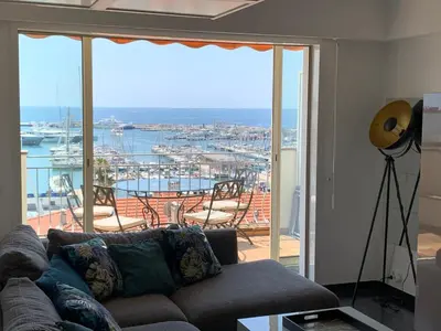 a living room with a couch and a view of a harbor at O Festival Palace, terrace with panoramic sea view in Cannes