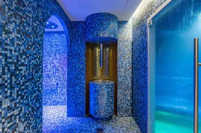 a bathroom with blue tiled walls and a shower at Hôtel Martinez, in The Unbound Collection by Hyatt in Cannes