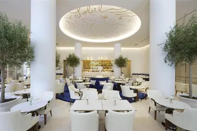 a restaurant with white tables and white chairs at Hôtel Martinez, in The Unbound Collection by Hyatt in Cannes