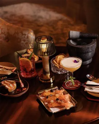 a table topped with plates of food and a drink at Hôtel Martinez, in The Unbound Collection by Hyatt in Cannes