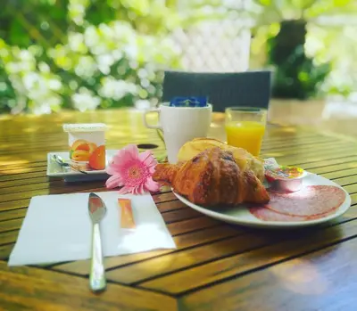 a plate of food on a wooden table with orange juice at Hotel Alexandre III in Cannes