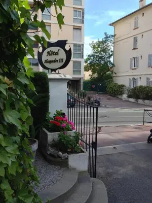 a sign for a hotel on the side of a building at Hotel Alexandre III in Cannes