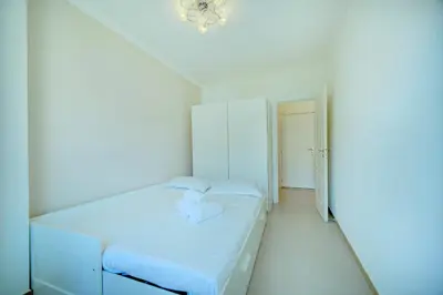 a white room with a bed and a chandelier at IMMOGROOM - Terrace - 2 bedrooms - Downtown - Air conditioning - Wifi in Cannes