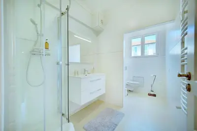 a white bathroom with a shower and a sink at IMMOGROOM - Terrace - 2 bedrooms - Downtown - Air conditioning - Wifi in Cannes