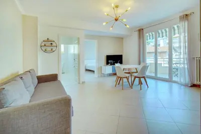 a living room with a couch and a table at IMMOGROOM - Terrace - 2 bedrooms - Downtown - Air conditioning - Wifi in Cannes