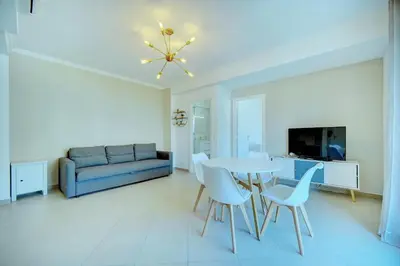 a living room with a table and chairs and a couch at IMMOGROOM - Terrace - 2 bedrooms - Downtown - Air conditioning - Wifi in Cannes