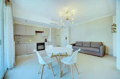 a kitchen and living room with a table and chairs at IMMOGROOM - Terrace - 2 bedrooms - Downtown - Air conditioning - Wifi in Cannes