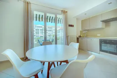 a kitchen with a white table and white chairs at IMMOGROOM - Terrace - 2 bedrooms - Downtown - Air conditioning - Wifi in Cannes