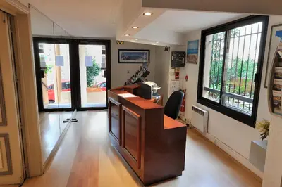 a office with a desk and windows in a building at Residhotel Les Coralynes in Cannes