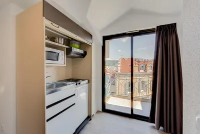 a kitchen with a view of a balcony at Residhotel Les Coralynes in Cannes