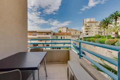 a balcony with a table and chairs and buildings at Residhotel Les Coralynes in Cannes