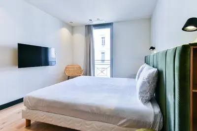 a bedroom with a bed and a flat screen tv at Florella Croisette Apartment in Cannes