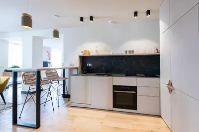 a kitchen with white cabinets and a table and chairs at Florella Croisette Apartment in Cannes
