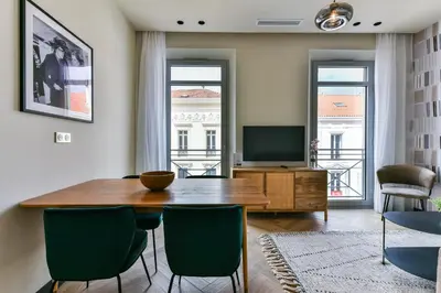 a living room with a table and chairs and a television at Florella Croisette Apartment in Cannes