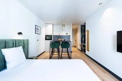 a bedroom with a bed and a kitchen with a table at Florella Croisette Apartment in Cannes