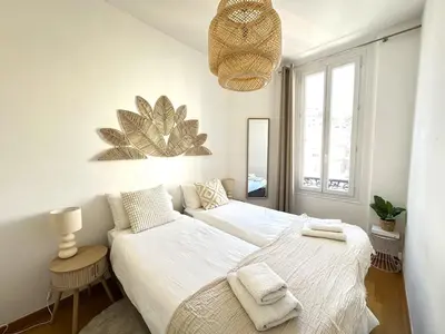 a white bedroom with a bed and a window at 3 bedrooms with sea view - 4 min Palais & beaches in Cannes