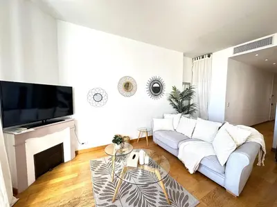 a living room with a white couch and a fireplace at 3 bedrooms with sea view - 4 min Palais & beaches in Cannes
