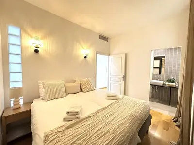a bedroom with a large bed with towels on it at 3 bedrooms with sea view - 4 min Palais & beaches in Cannes