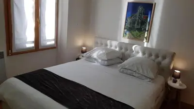 a bedroom with a large white bed with two pillows at CLEM SOLEIL in Cannes