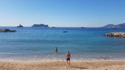 two people standing on a beach in the water at CLEM SOLEIL in Cannes