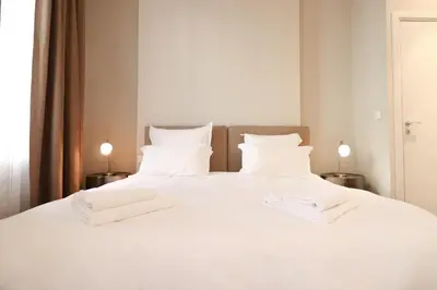 a large white bed with two white towels on it at Residence Bivouac in Cannes