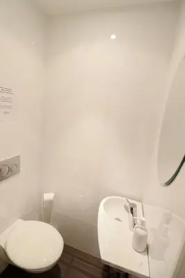 a white bathroom with a toilet and a sink at Residence Bivouac in Cannes