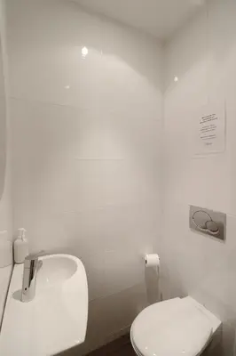 a white bathroom with a toilet and a sink at Residence Bivouac in Cannes