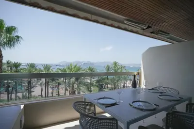 a dining room with a table and chairs and a large window at Blvd De La Croisette 82A, Cannes, La Réale in Cannes