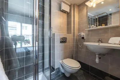 a bathroom with a toilet and a sink and a shower at Hôtel Hoche in Cannes