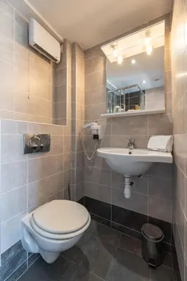 a bathroom with a toilet and a sink at Hôtel Hoche in Cannes