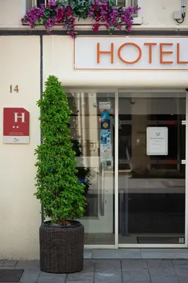 a potted tree in front of a hotel at Hôtel Hoche in Cannes