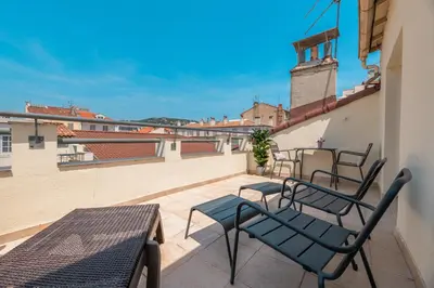a patio with chairs and tables on a balcony at Hôtel Hoche in Cannes