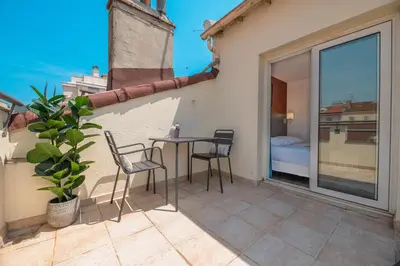 a patio with a table and chairs on a balcony at Hôtel Hoche in Cannes
