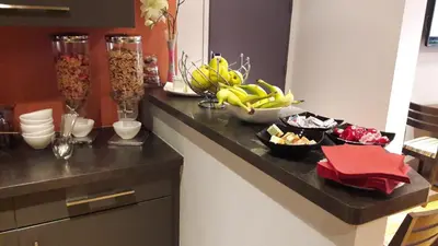 a kitchen counter with bananas and bowls of food on it at Hôtel Hoche in Cannes