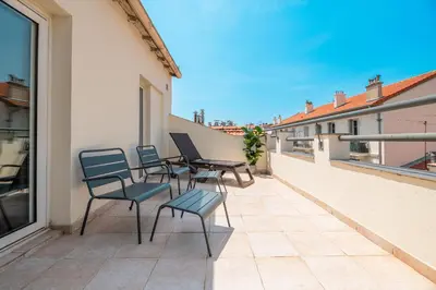 a patio with chairs and tables on a balcony at Hôtel Hoche in Cannes