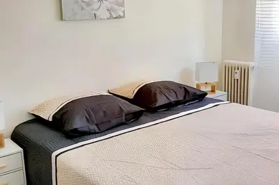 a bed with two pillows on it in a bedroom at Appartement charmant avec vue sur la mer au Cannet - 58 m² in Le Cannet
