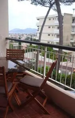 two chairs sitting on a balcony with a view of a building at Appartement charmant avec vue sur la mer au Cannet - 58 m² in Le Cannet