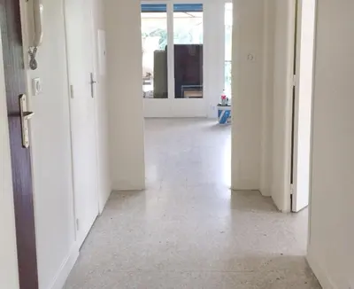 an empty hallway with white walls and white floors at Appartement charmant avec vue sur la mer au Cannet - 58 m² in Le Cannet