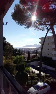 a white car parked on a balcony with the sun shining at Appartement charmant avec vue sur la mer au Cannet - 58 m² in Le Cannet