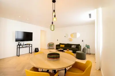 a living room with a table and yellow chairs at Residence Buttura in Cannes