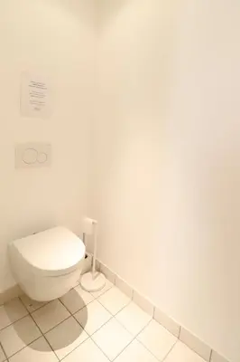 a bathroom with a toilet in a white room at Residence Buttura in Cannes