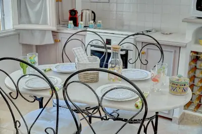 a table with chairs and plates on it in a kitchen at IMMOGROOM - Cosy Apartment - Quiet Place - Provencal style in Cannes