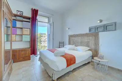 a bedroom with a large bed and a window at IMMOGROOM - Cosy Apartment - Quiet Place - Provencal style in Cannes