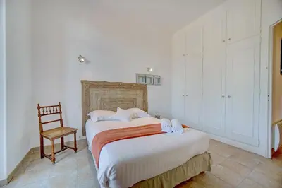 a bedroom with two beds and a chair in it at IMMOGROOM - Cosy Apartment - Quiet Place - Provencal style in Cannes