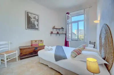 a bedroom with a large bed and a window at IMMOGROOM - Cosy Apartment - Quiet Place - Provencal style in Cannes