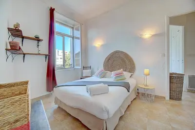 a bedroom with a large bed and a large window at IMMOGROOM - Cosy Apartment - Quiet Place - Provencal style in Cannes