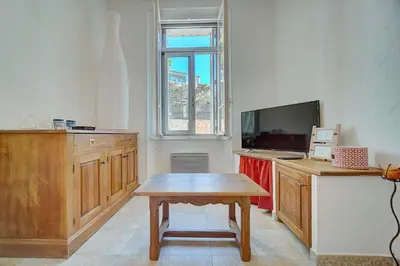 a living room with a table and a tv at IMMOGROOM - Cosy Apartment - Quiet Place - Provencal style in Cannes