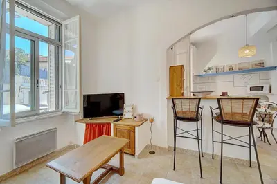 a living room with a table and two chairs at IMMOGROOM - Cosy Apartment - Quiet Place - Provencal style in Cannes