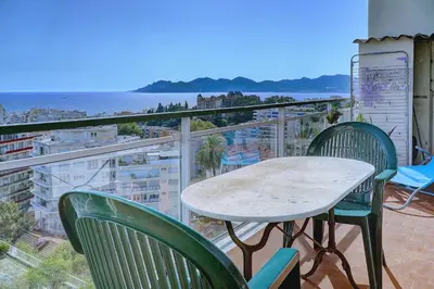 a table and chairs on a balcony with a view of the ocean at IMMOGROOM - Terrace- Parking - Quiet place - CONGRESSBEACHES in Cannes